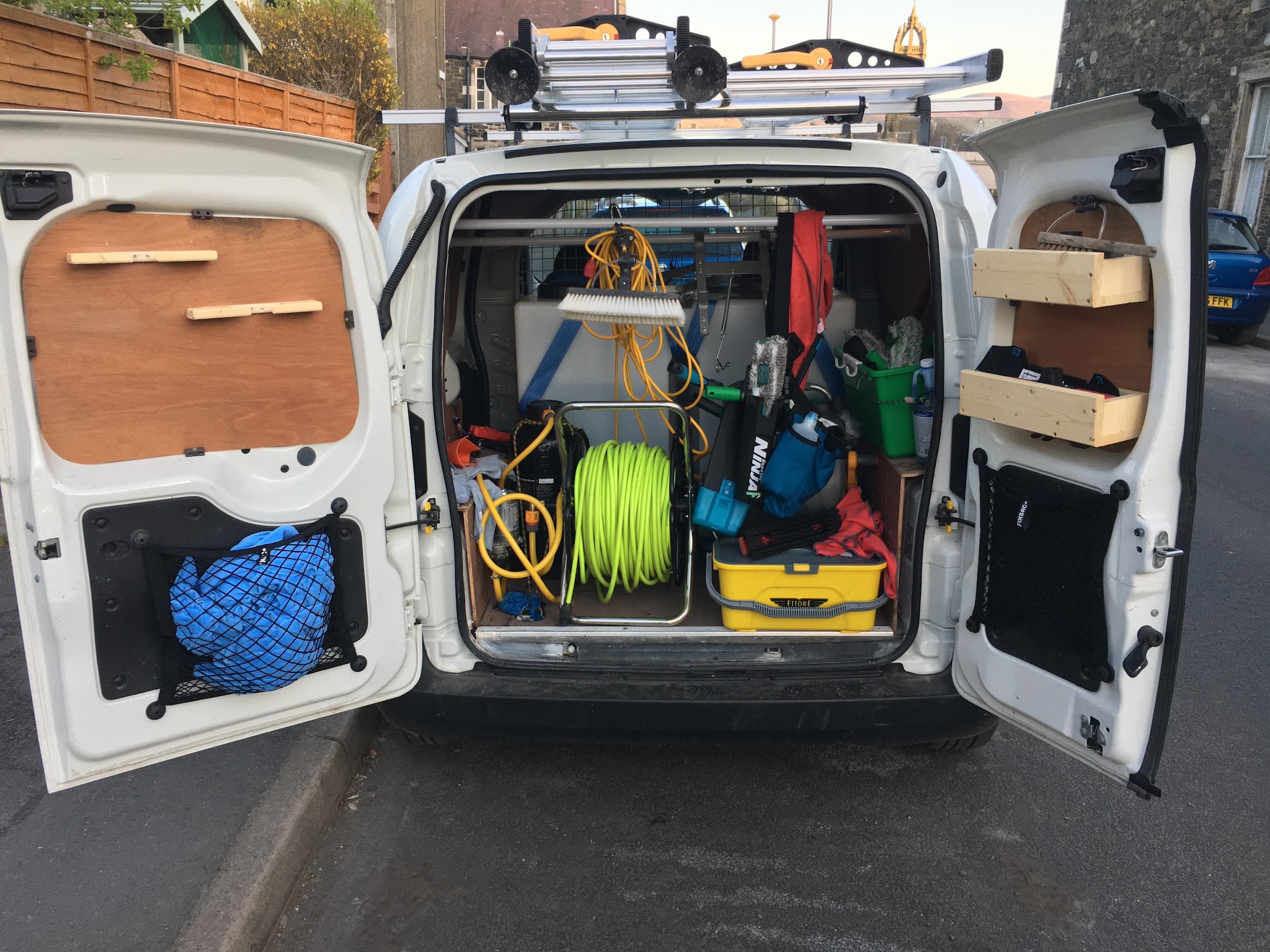 The back of the Pure Water Window Cleans van, ladders on the roof and hose reels inside